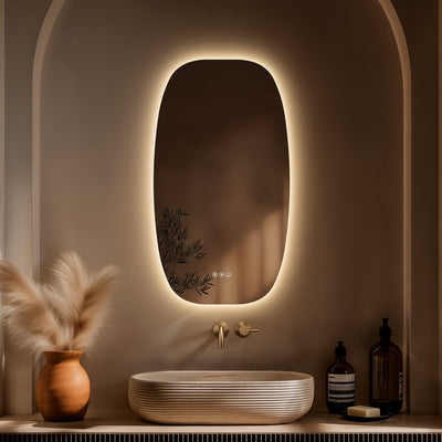 Claris Barrel 50 x 90cm LED bathroom mirror with touch sensor and backlit frame, styled in a warm neutral bathroom with brushed brass tap and modern basin - Origins Living mirror at BathLab