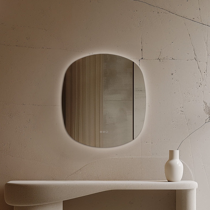 Claris Curve Oblong 70 x 78cm LED bathroom mirror with touch sensor and backlit frame, styled in a warm neutral bathroom - Origins Living mirror at BathLab